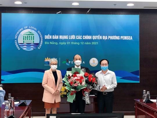 Dr Le Quang Nam at the ceremony holding flowers